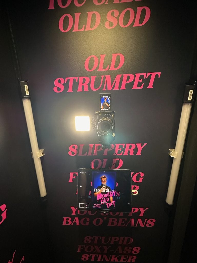 Close-up of a vintage typewriter with bold pink text on a black background, used for event branding at Full Frame Events. Photograph showcasing creative event branding and promotional displays by Full Frame Events. An eye-catching display featuring retro-style typography and a tablet showing event details, highlighting Full Frame Events' innovative marketing solutions. relevance.