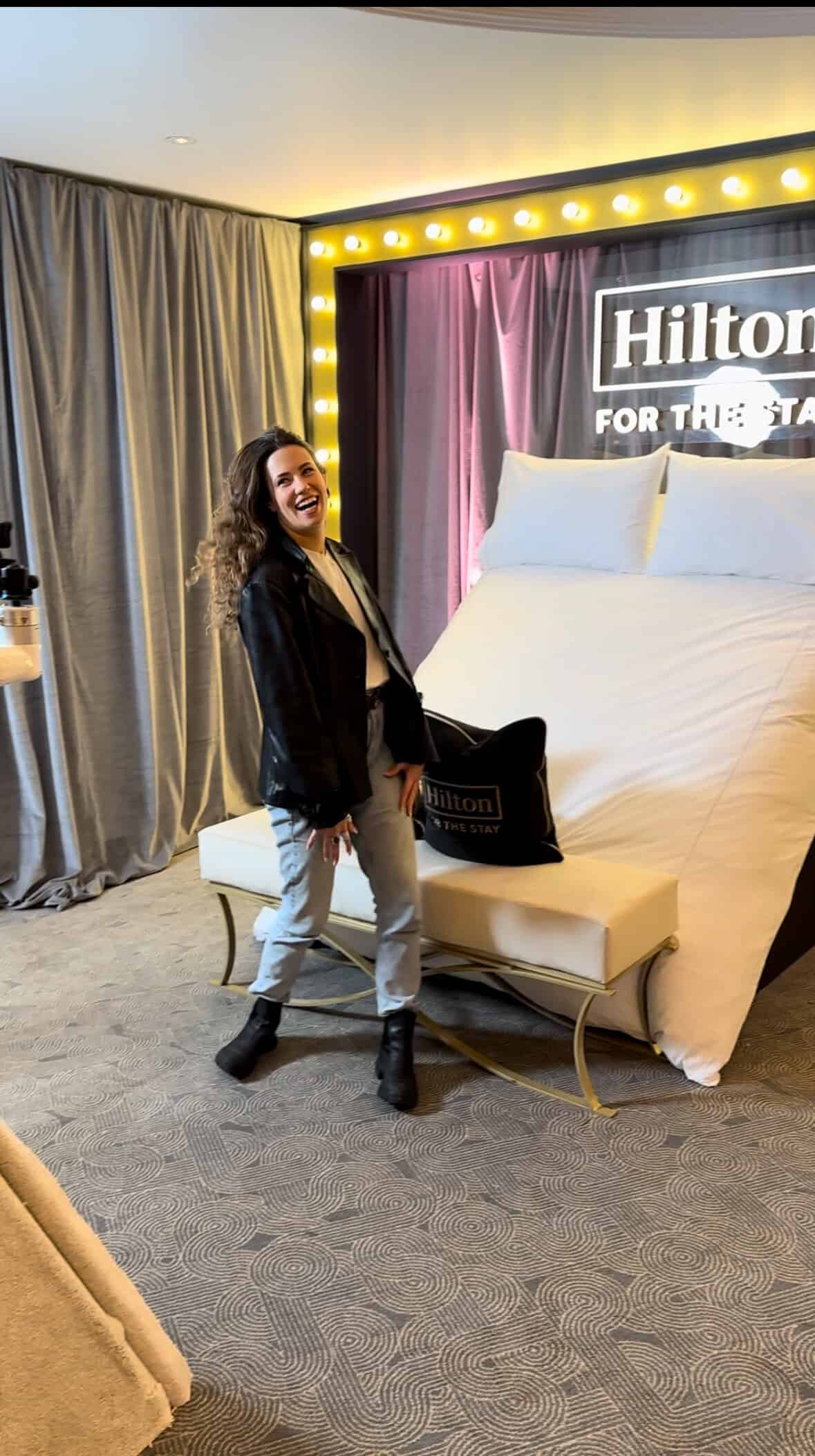 Luxury hotel room with Hilton branding, elegant decor, and ambient lighting.