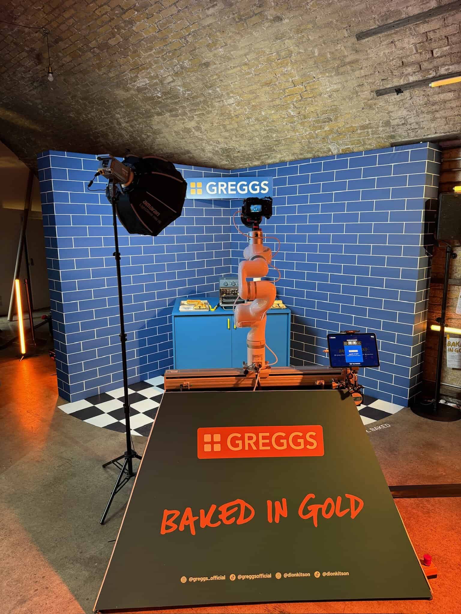 Vibrant product display setup at an event with bright lighting and branding for Greggs bakery.