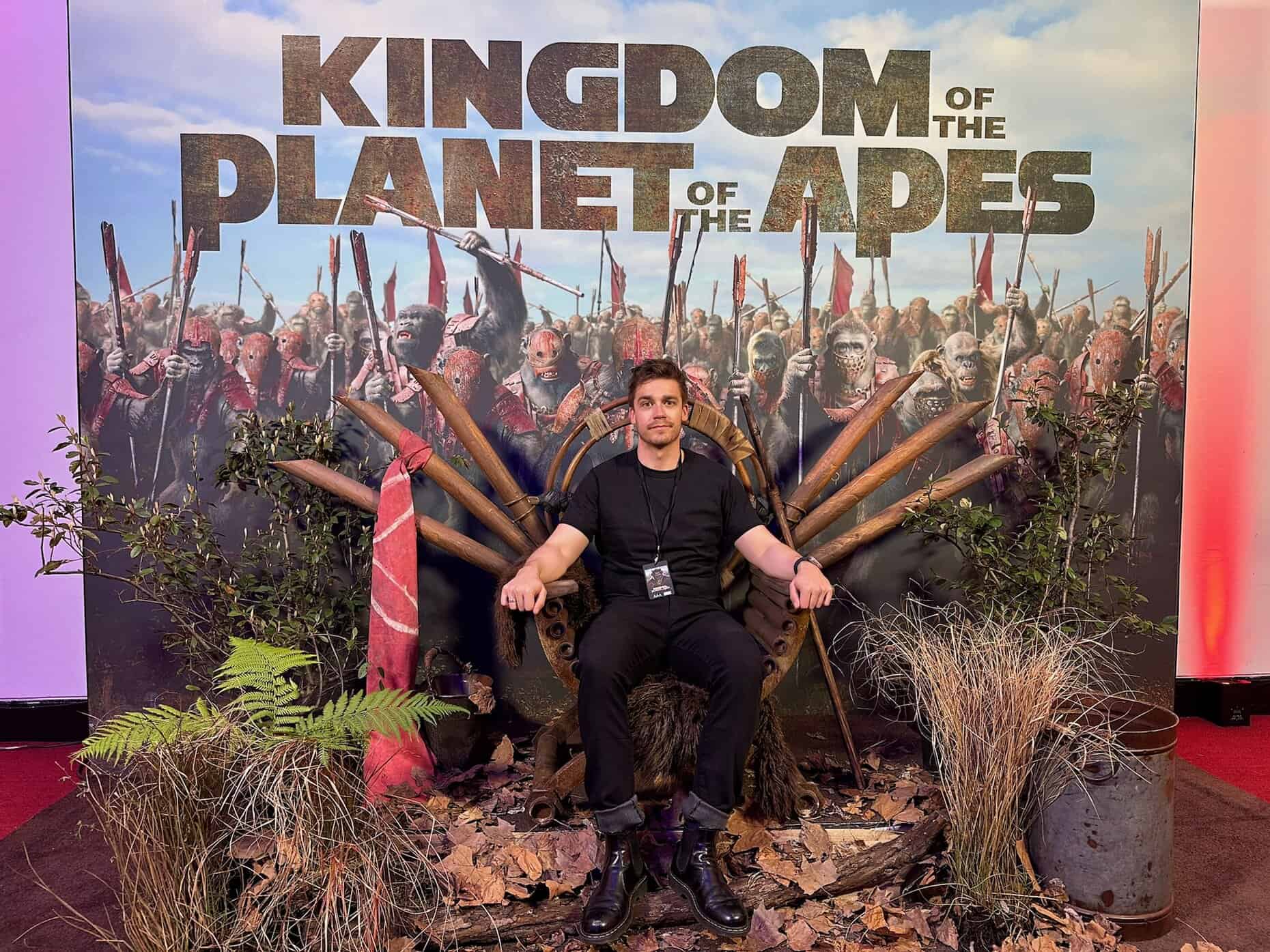 Intricate throne surrounded by plants and fallen leaves, with a detailed "Kingdom of the Planet of the Apes" backdrop at Full Frame Events.